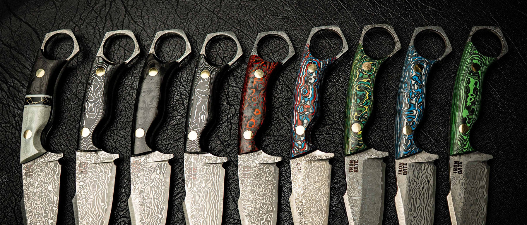Iron Gate Knives Mini Hunter lineup — nine Damascus and stonewashed Mini Hunters fanned on dark leather