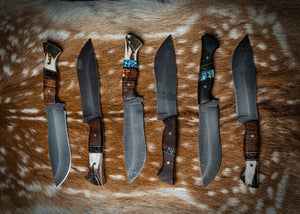 Six one off Iron Gate knives laid out on deer hide