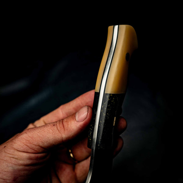 Hunter — Black & Gold Restone with Vintage Ivory G10 — In-hand view | Iron Gate Knives