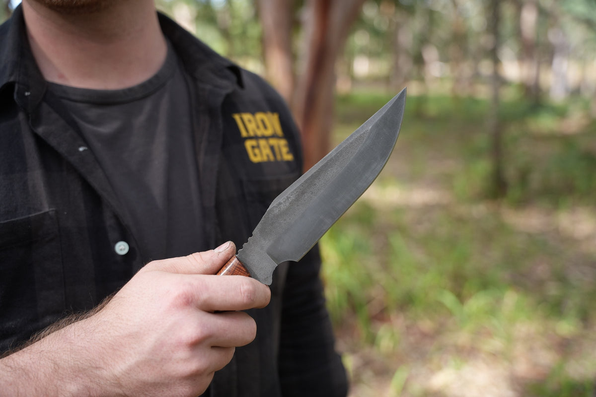 Iron Gate maker holding a Bowie in the bush