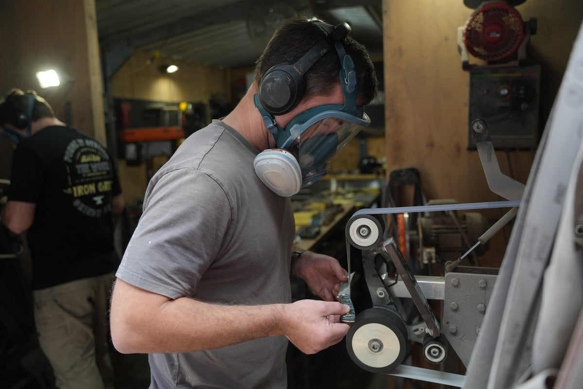 Knifemaker shaping a blade on a 2x72 belt grinder