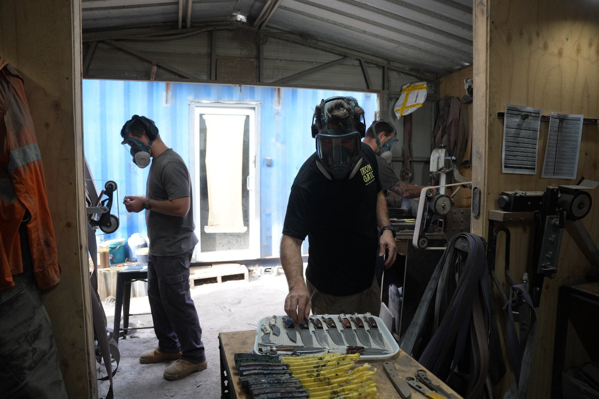 The Iron Gate Knives team grinding blades side by side in the Anna Bay workshop