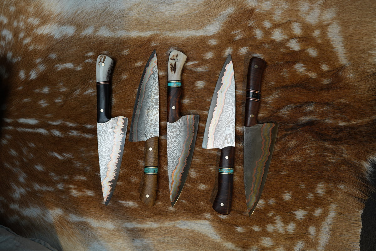 Damascus kitchen knives laid on a deer hide