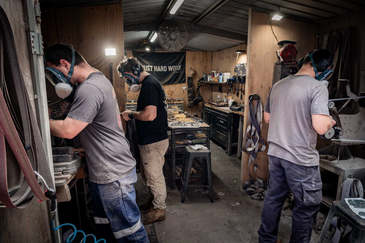 Three makers in respirators working side by side in the workshop